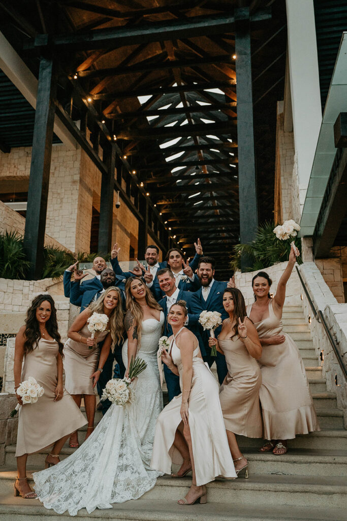 The wedding party posing with white roses. 