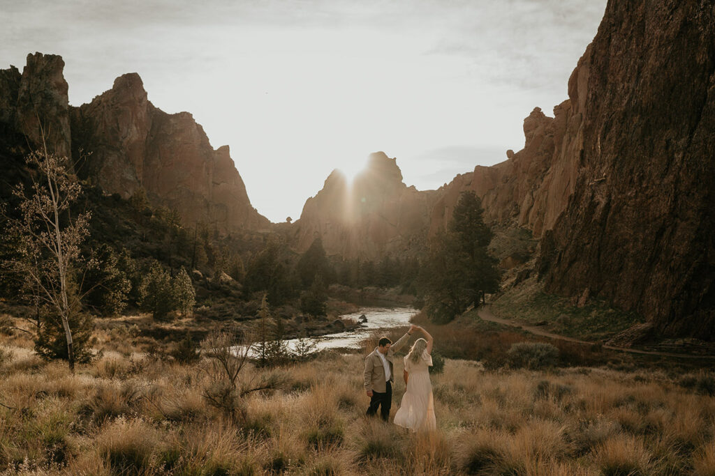 a couple dancing with deep river canyons in the background. 