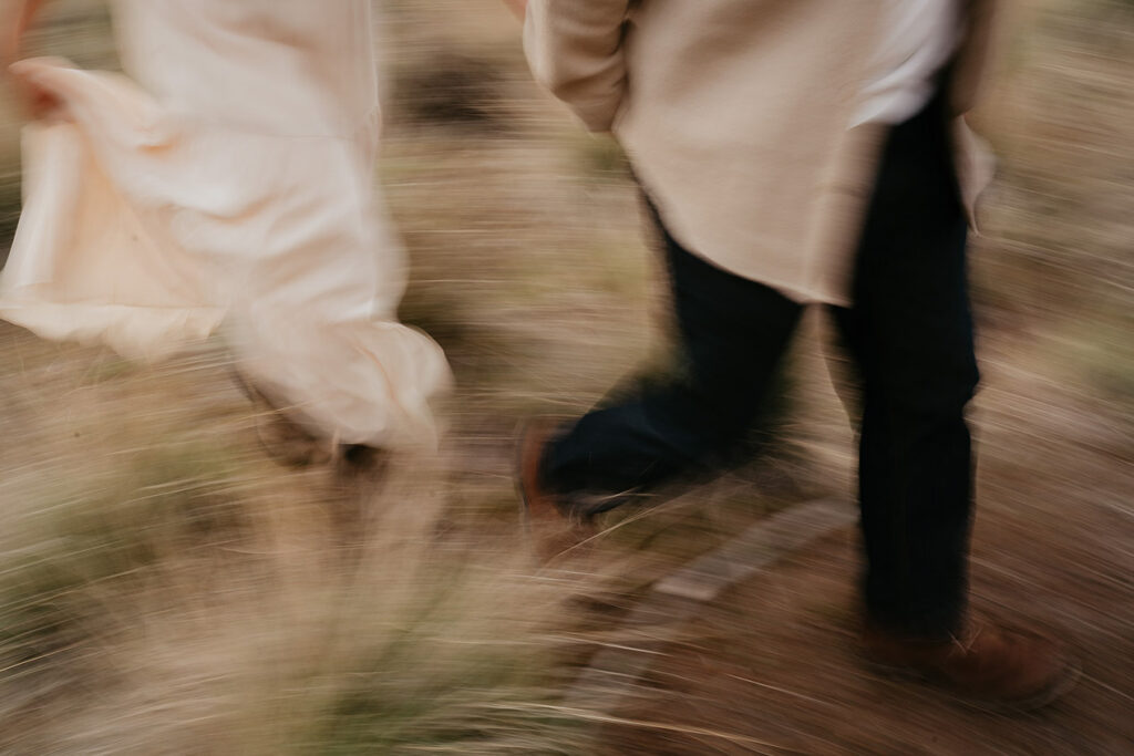 A blurry photo of a couple running in a field. 