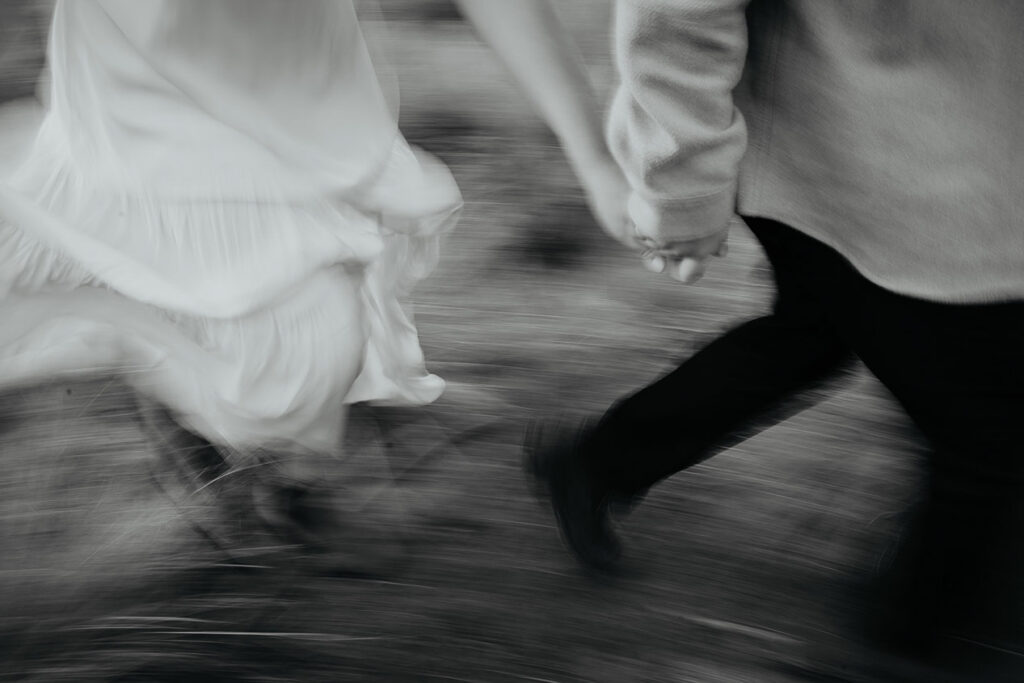 A blurry photo of a couple running in a field. 