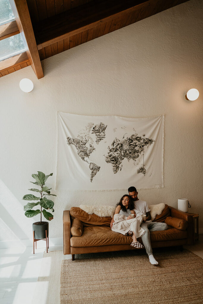 the bride and groom cuddling on a couch. 