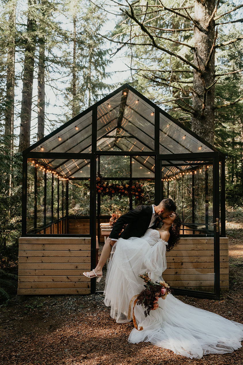 The couple standing in front of the reception area at The Woodlands House venue.