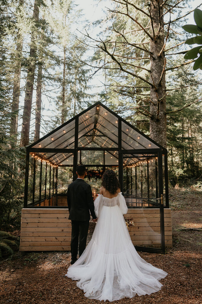 The newlyweds walking into the green house at The Woodlands house venue. 