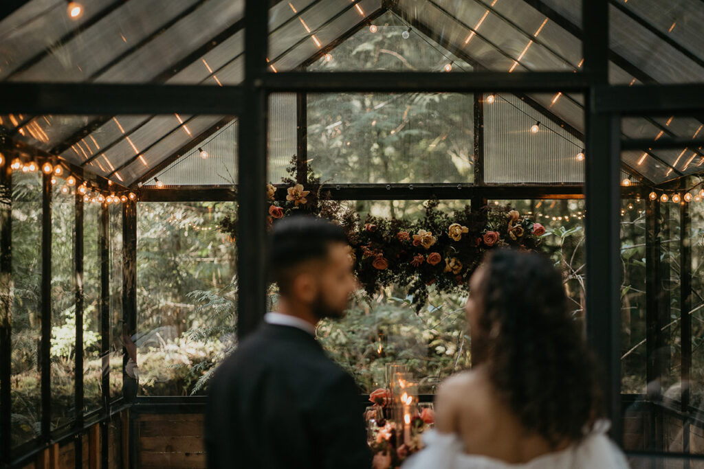 The newlyweds walking into the green house at The Woodlands house venue. 