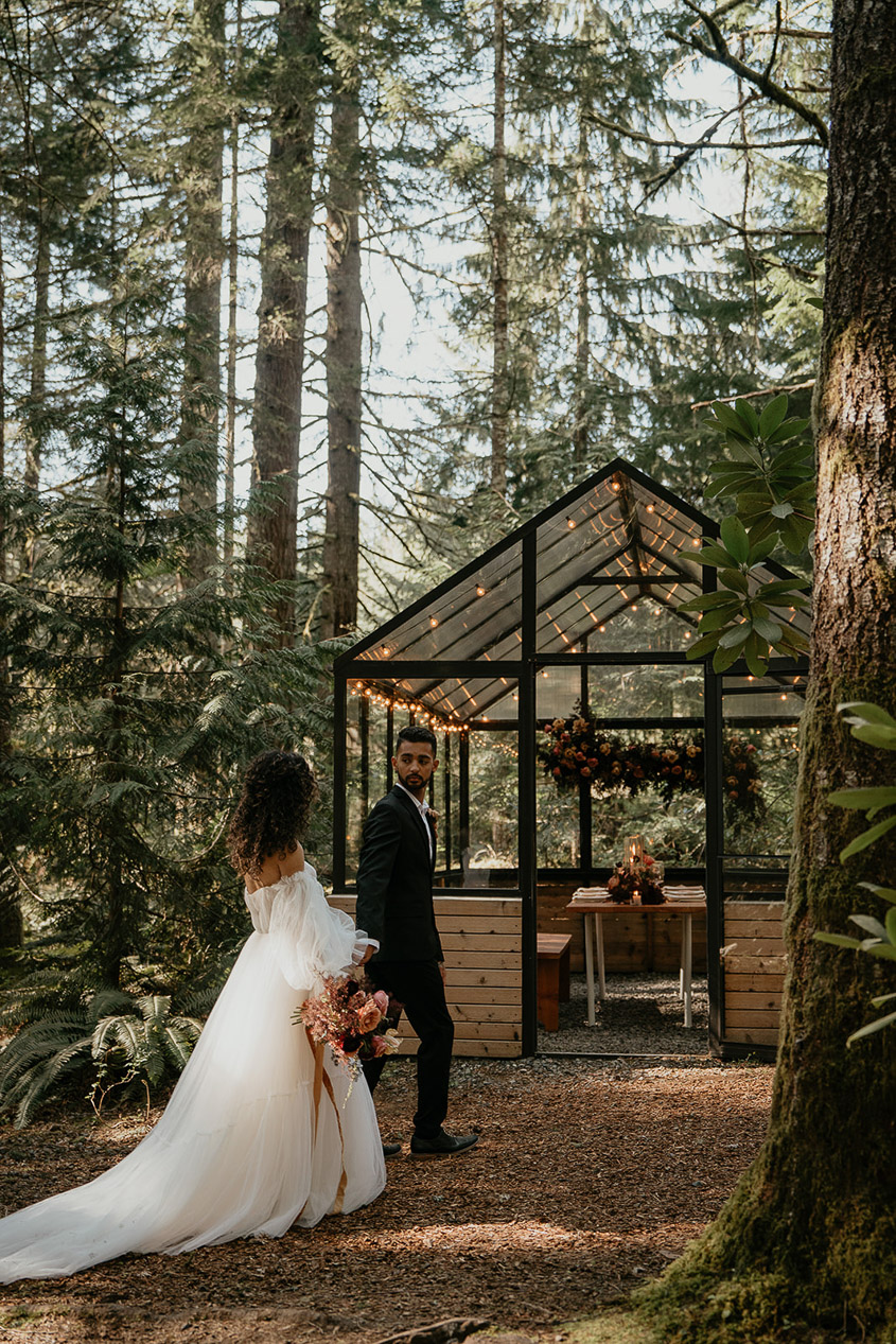 The newlyweds walking into the green house at The Woodlands house venue. 