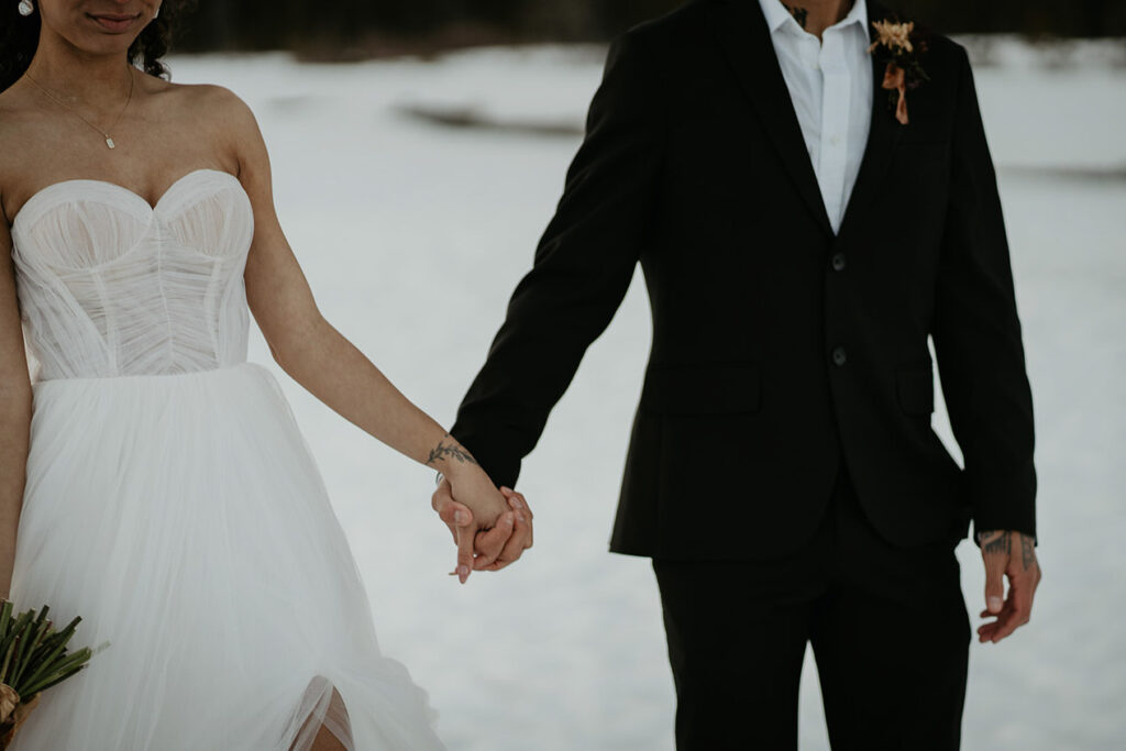 the newlyweds holding each other in the snow with Mt Hood in the background.