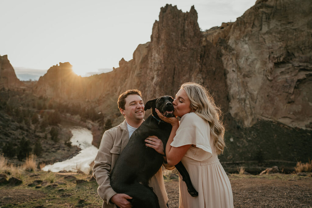 A couple hugging their dog at Smith Rock State Park. 