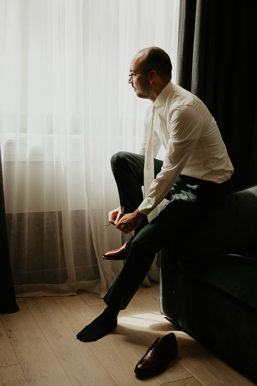 the groom tying his shoes. 