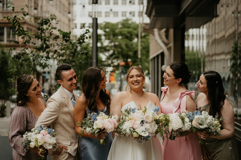 the bride smiling with her wedding party in downtown Portland. 