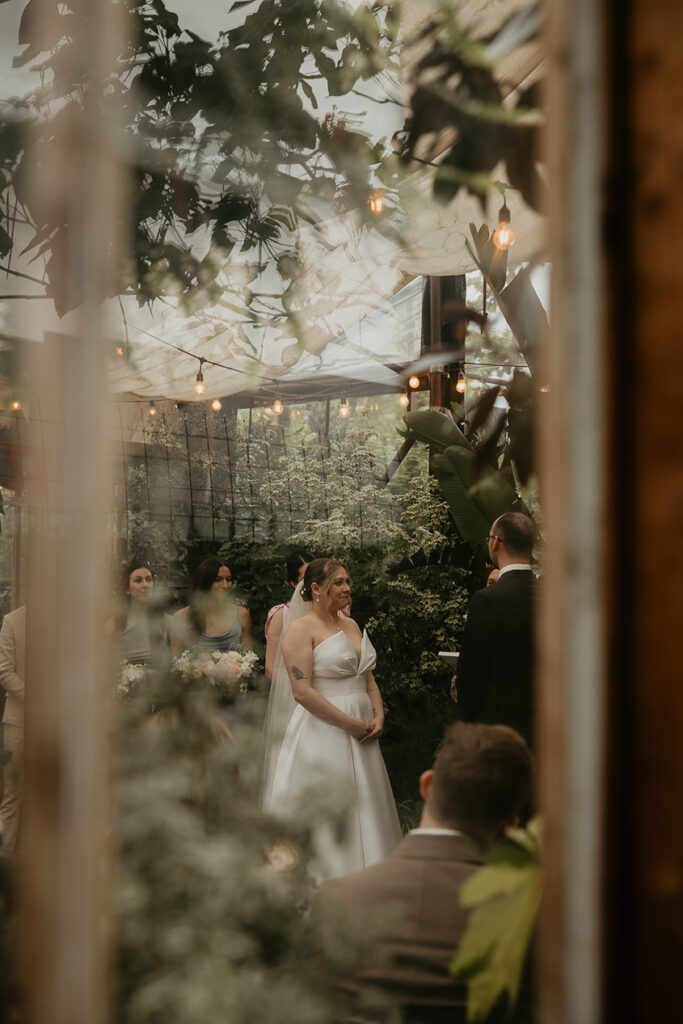 the bride and groom during the Blockhouse PDX wedding through a window. 