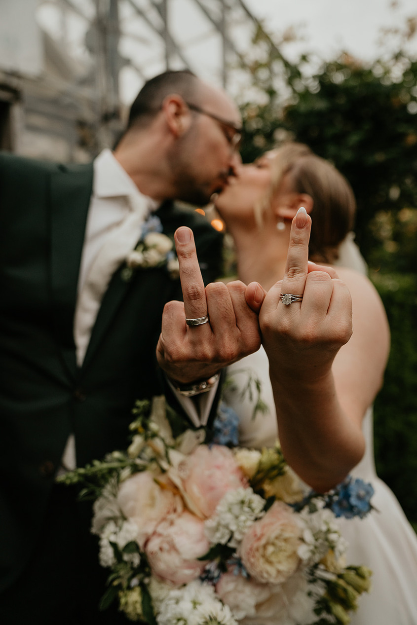 the bride and groom showing off their rings and kissing during their Blockhouse PDX wedding. 