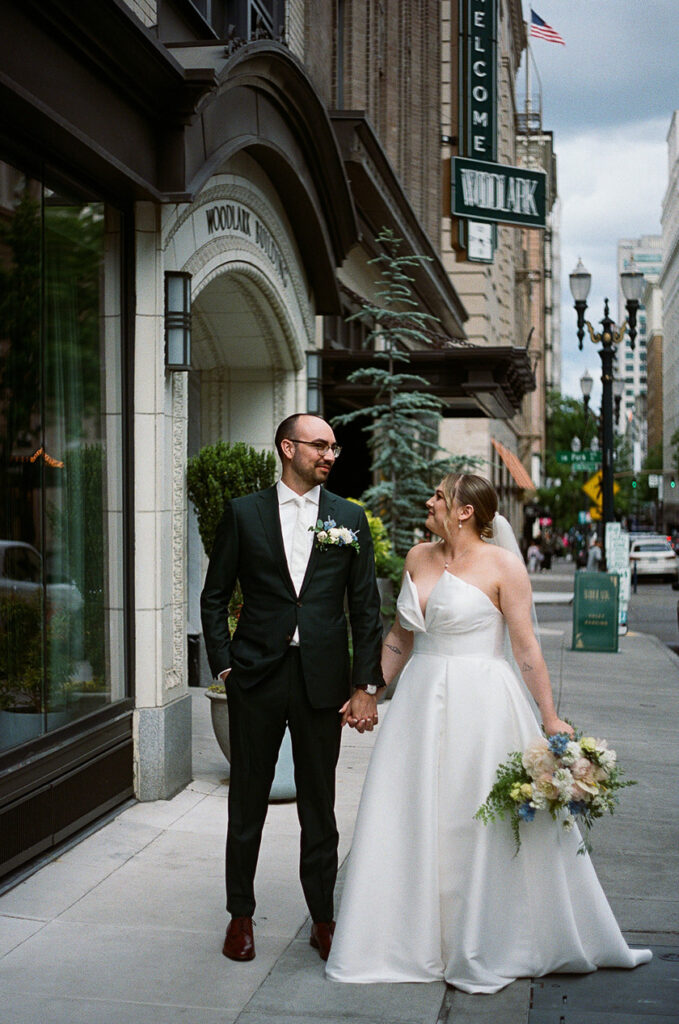 the bride and groom holding hands walking around downtown Portland. 