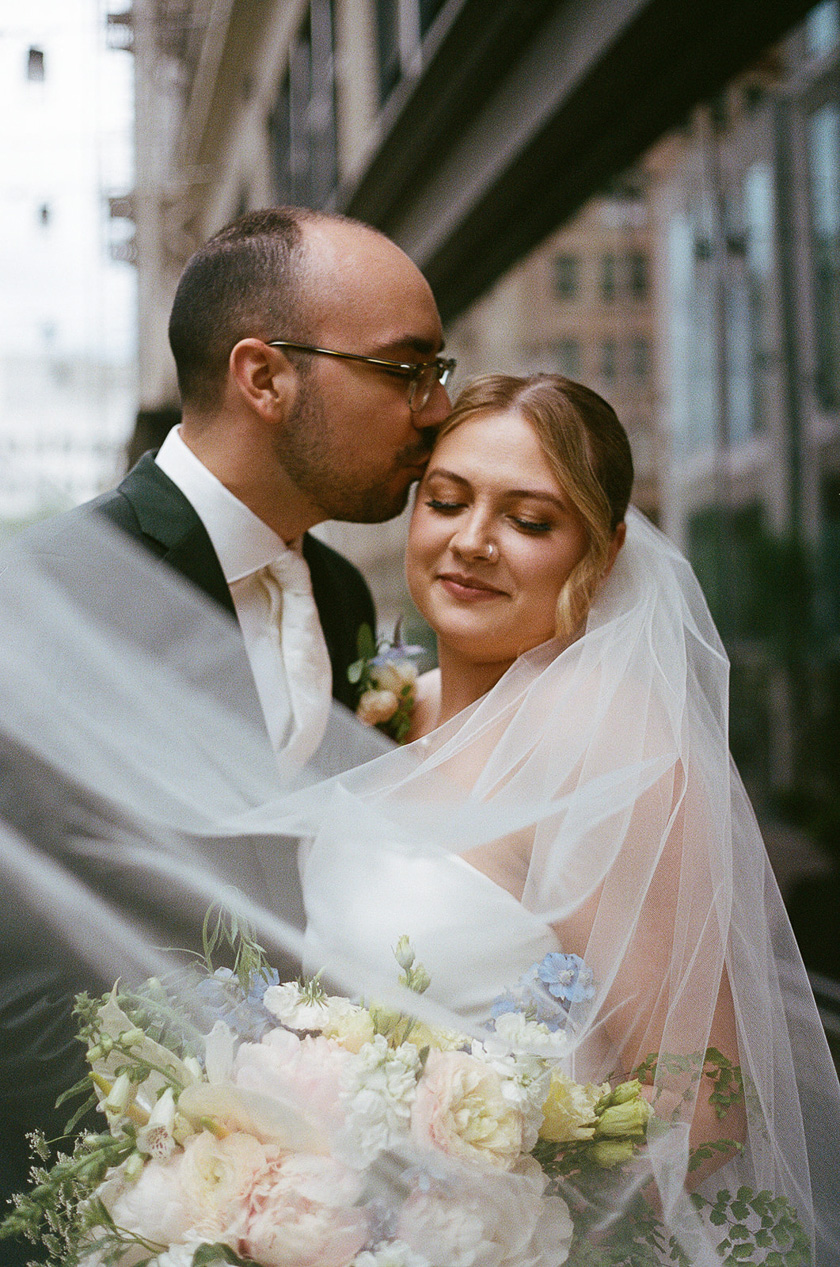 the bride and groom kissing in downtown Portland. 