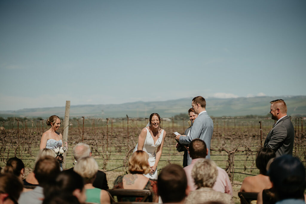 the bride laughing during her Dusted Valley wedding as the groom shares a funny moment during his vows. 