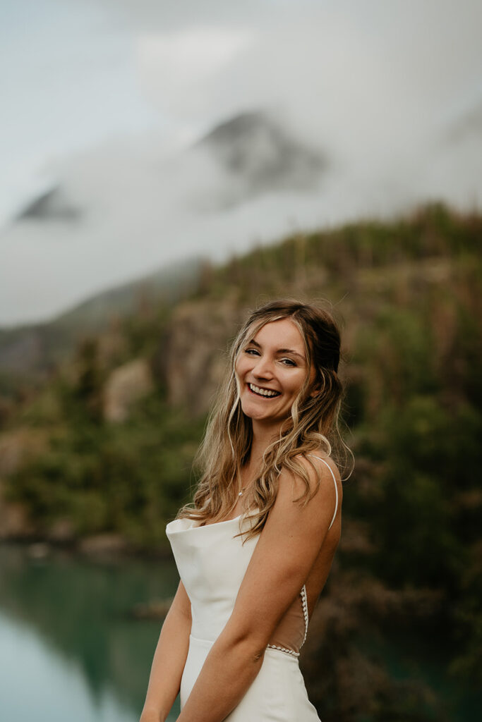 A bride smiling with mountains in the background. 