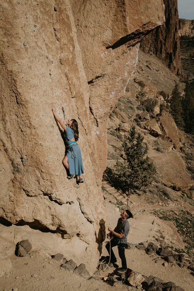 A couple rock-climbing in Smith Rock. 