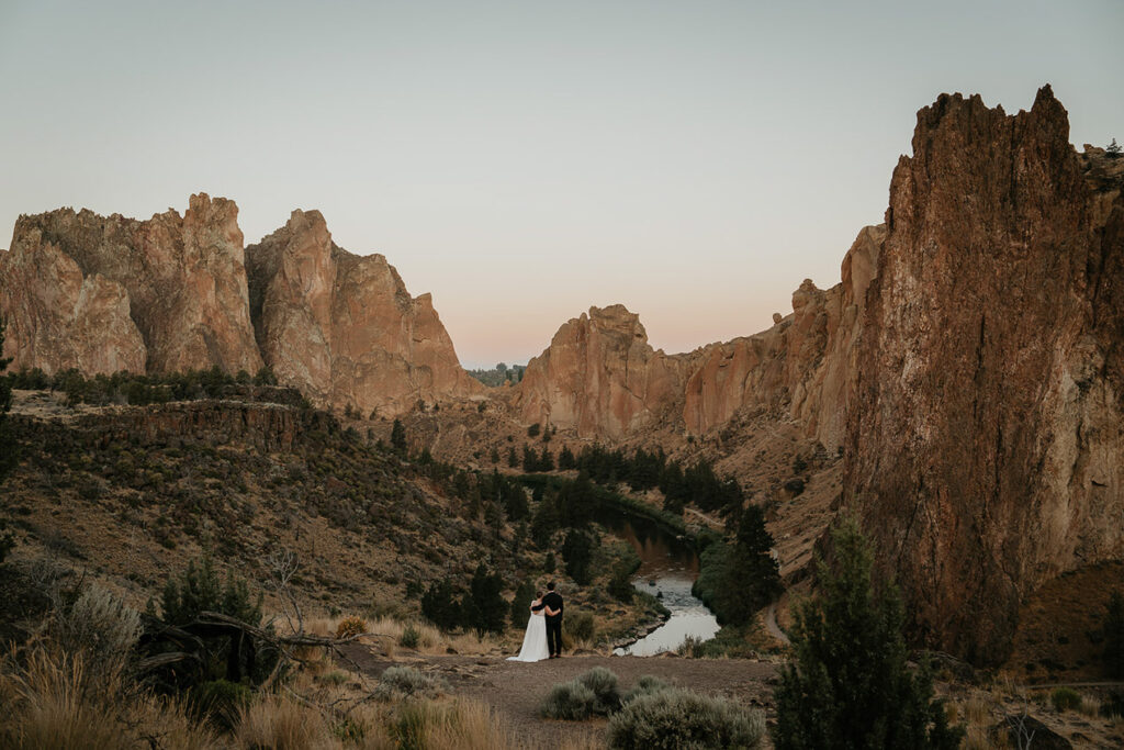 A couple holding each other while looking out at Smith Rock. 