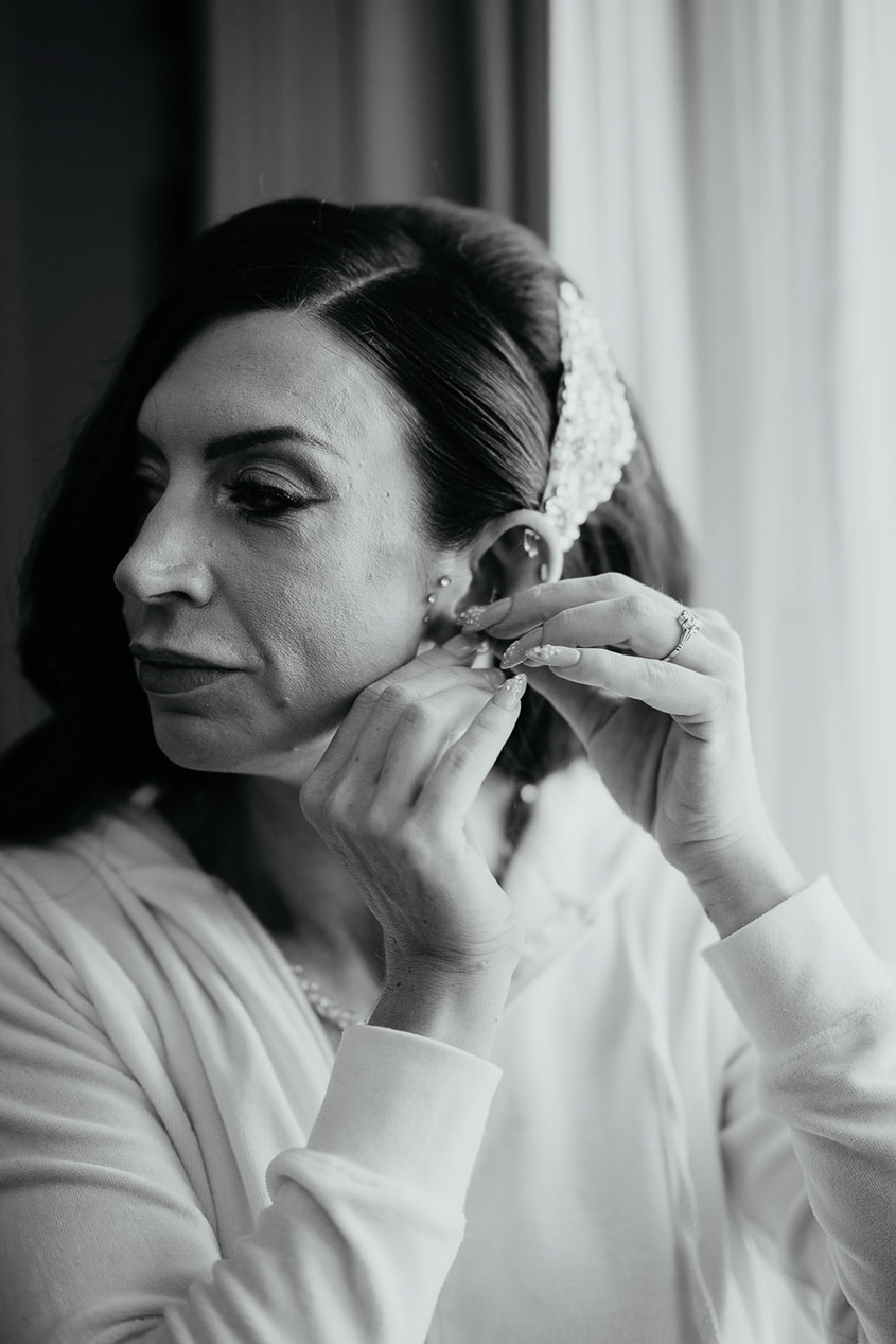 the bride putting on her earrings. 