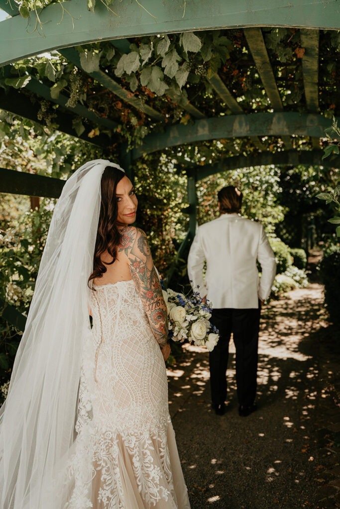 the groom and bride under a pergola at Deepwood Museum and Gardens. 