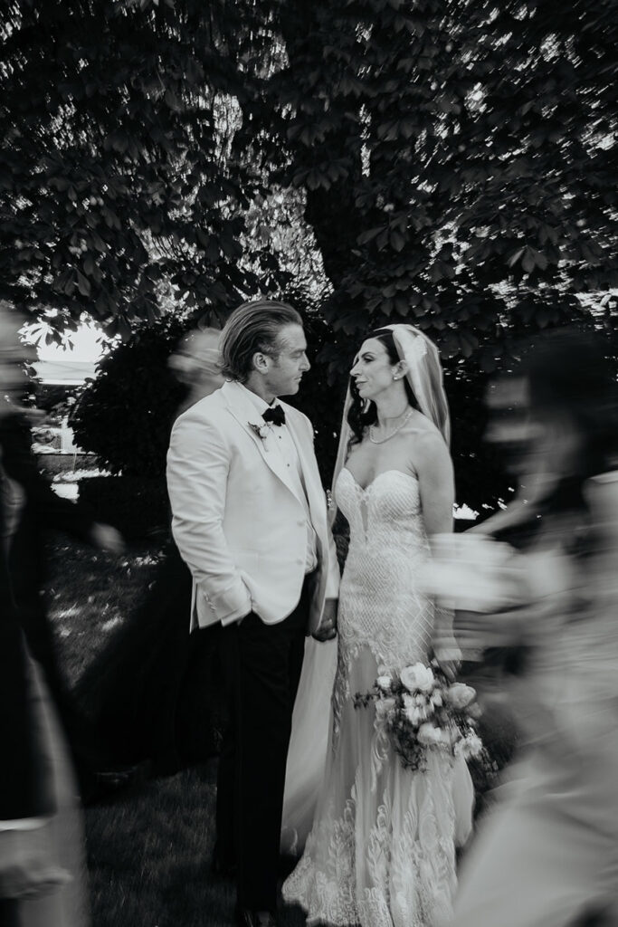 the bride and groom holding hands while their wedding party walks by. 