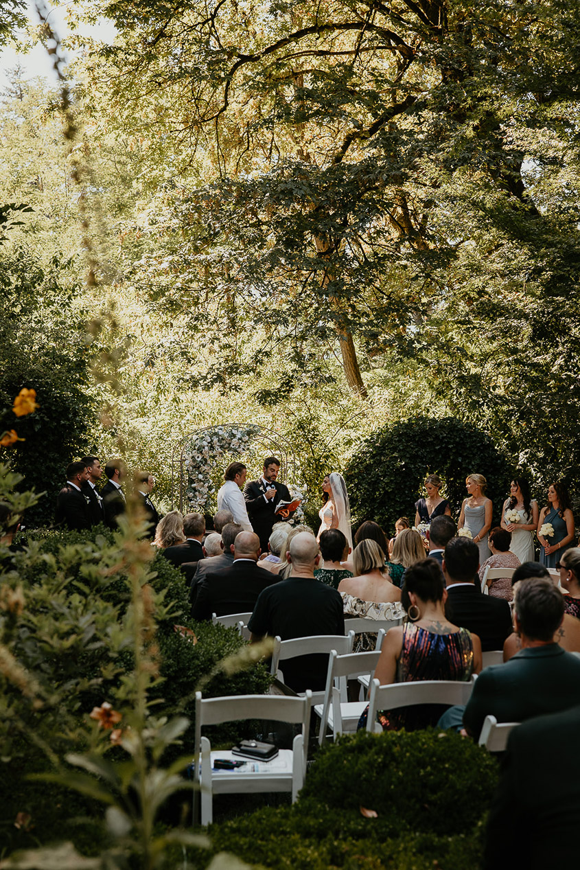 the bride, groom, and wedding guests in a garden at Deepwood Museum and Gardens. 