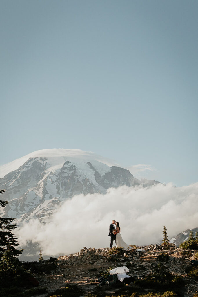 A couple kissing with Mt Rainier in the background. 