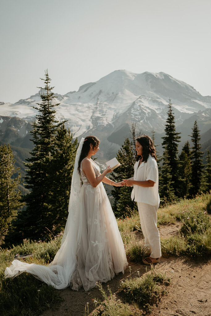 A couple reading their wedding vows as they elope in Mt Rainier. 