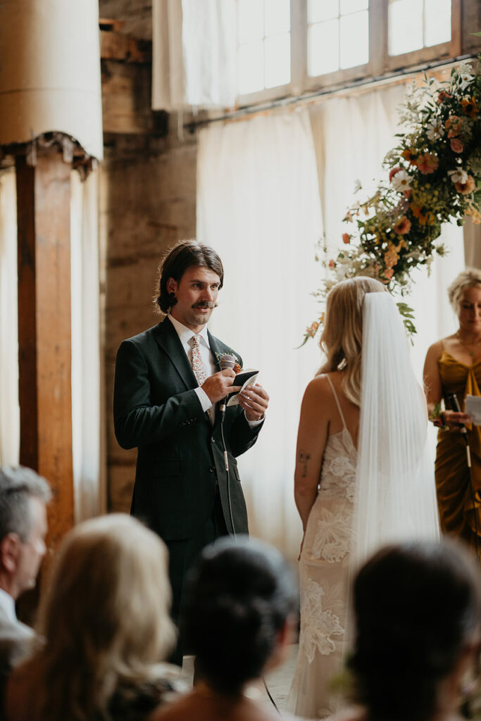 the groom giving his vows to his wife during their ceremony at The Ruins at the Astor. 