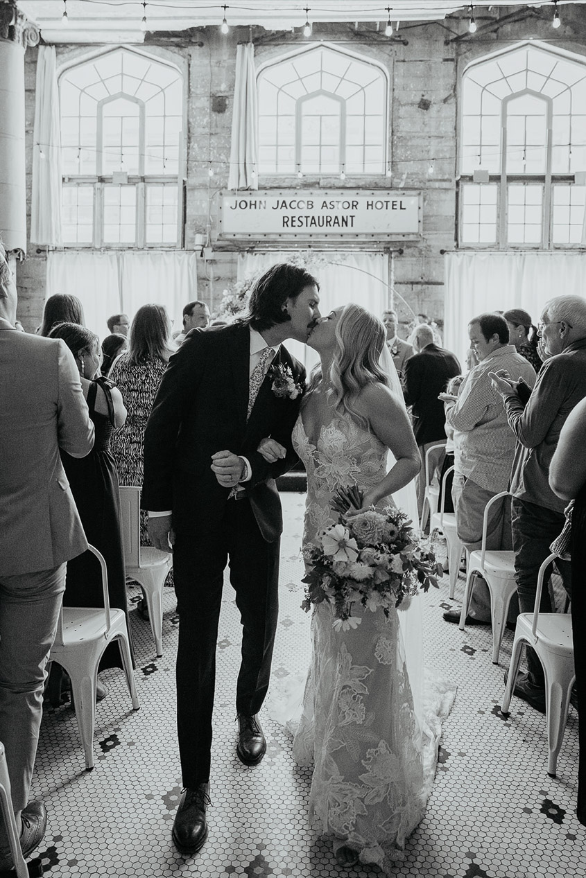 The newlyweds kissing after their ceremony at The Ruins at the Astor. 