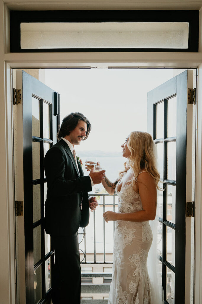 the bride and groom sharing a drink in a doorway. 