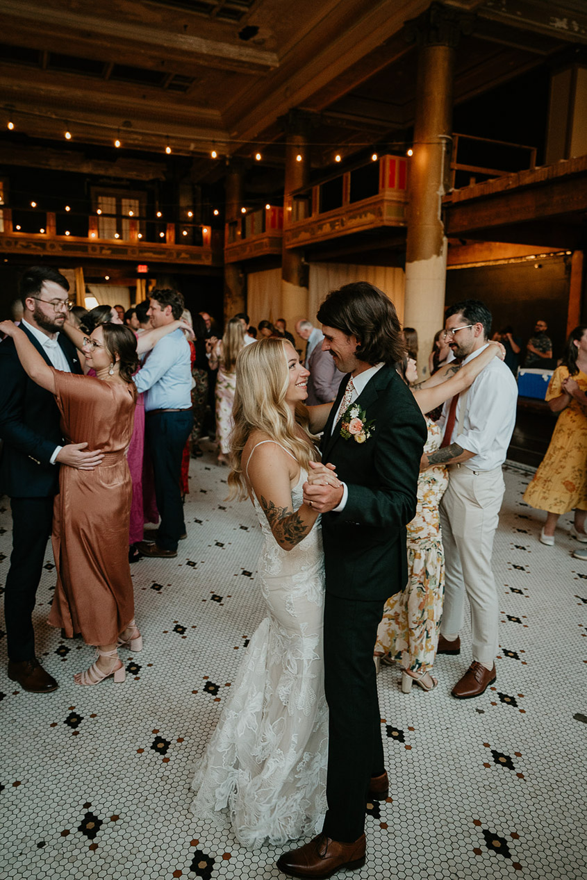 The newlyweds holding hands and dancing togeter. 