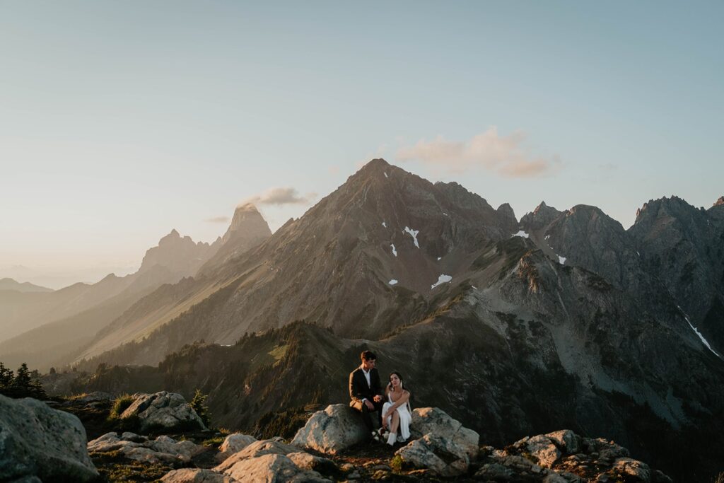 Bride and groom sit on a mountain trail after their elopement in the North Cascades