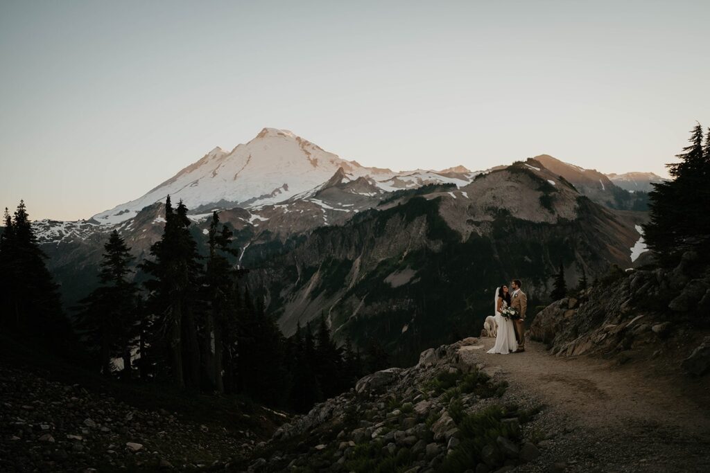 Bride and groom stand on a mountain trail during their elopement in the North Cascades