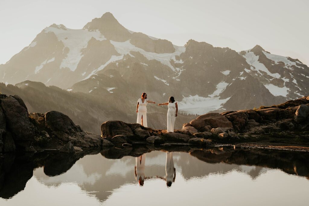 Brides reach out their hands to each during their elopement at Artist Point 