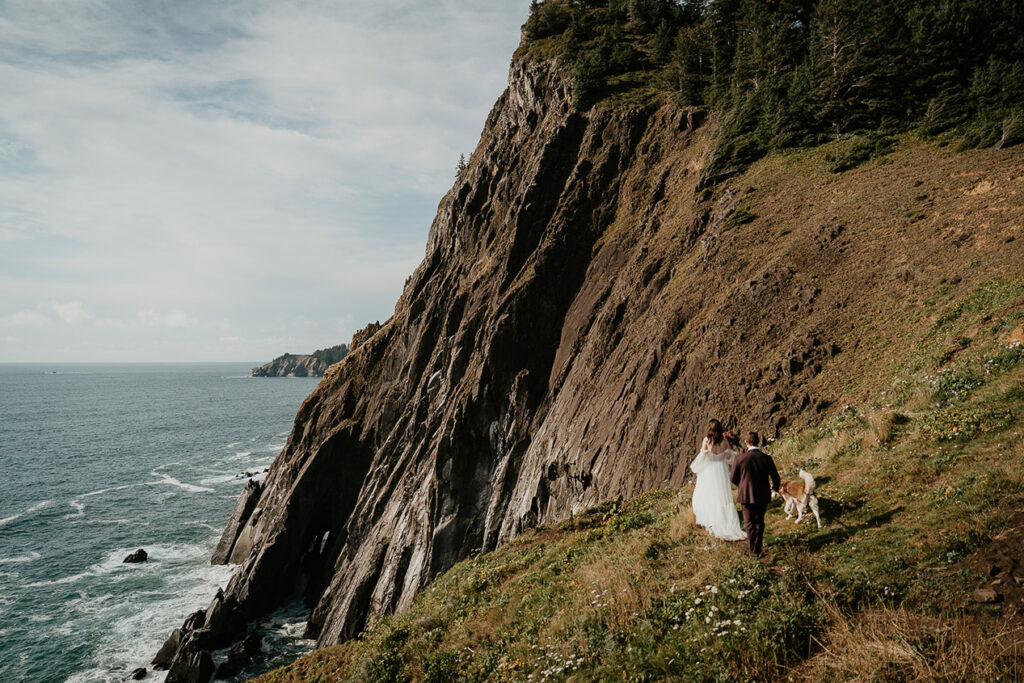 The couple hiking along the Oregon cliffside with their dog. 