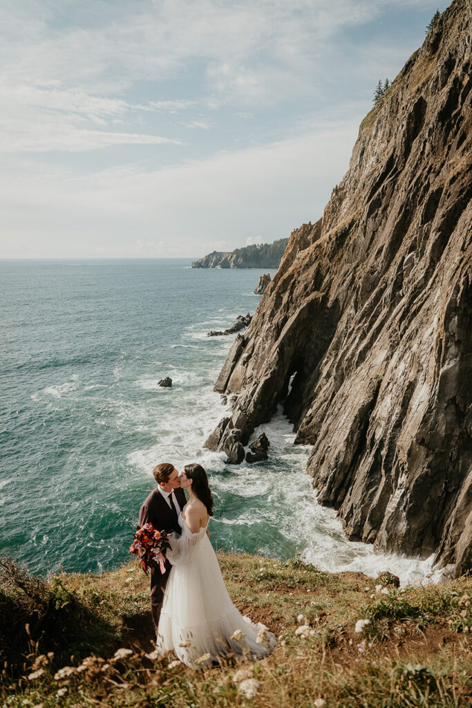 the newlyweds kissing with the Oregon cliffside in the background. 