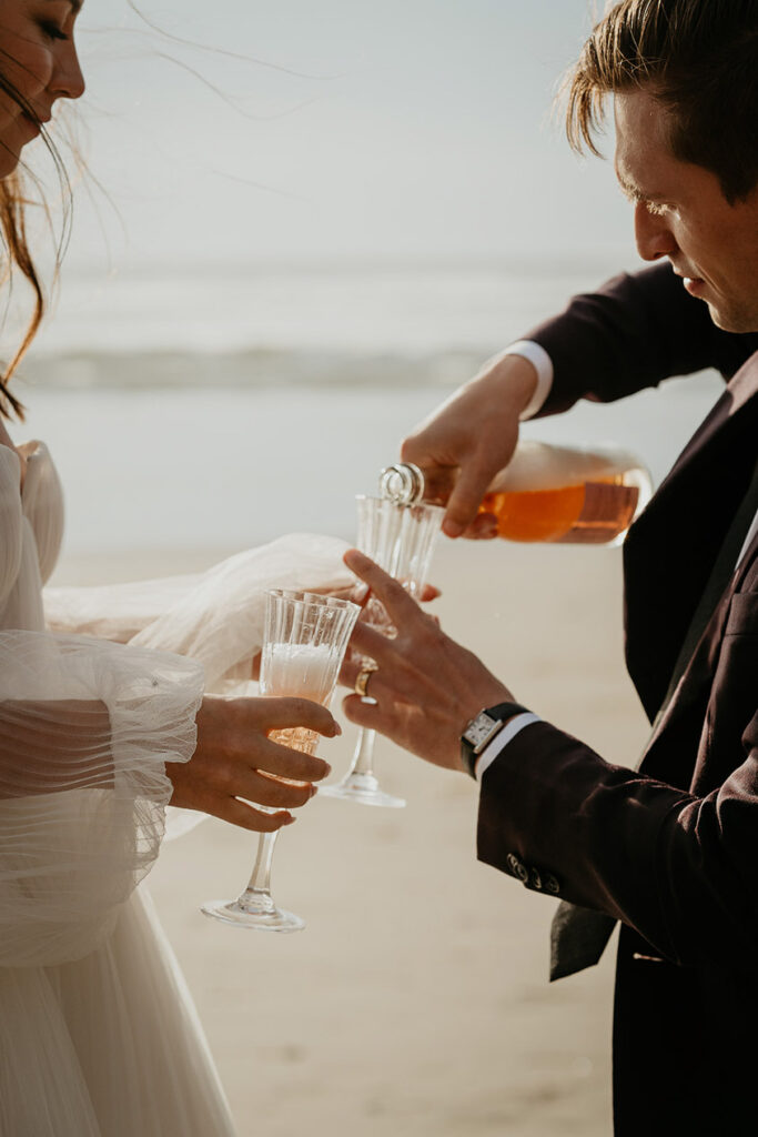 the newlyweds pouring a class of champagne on the Oregon Coast. 