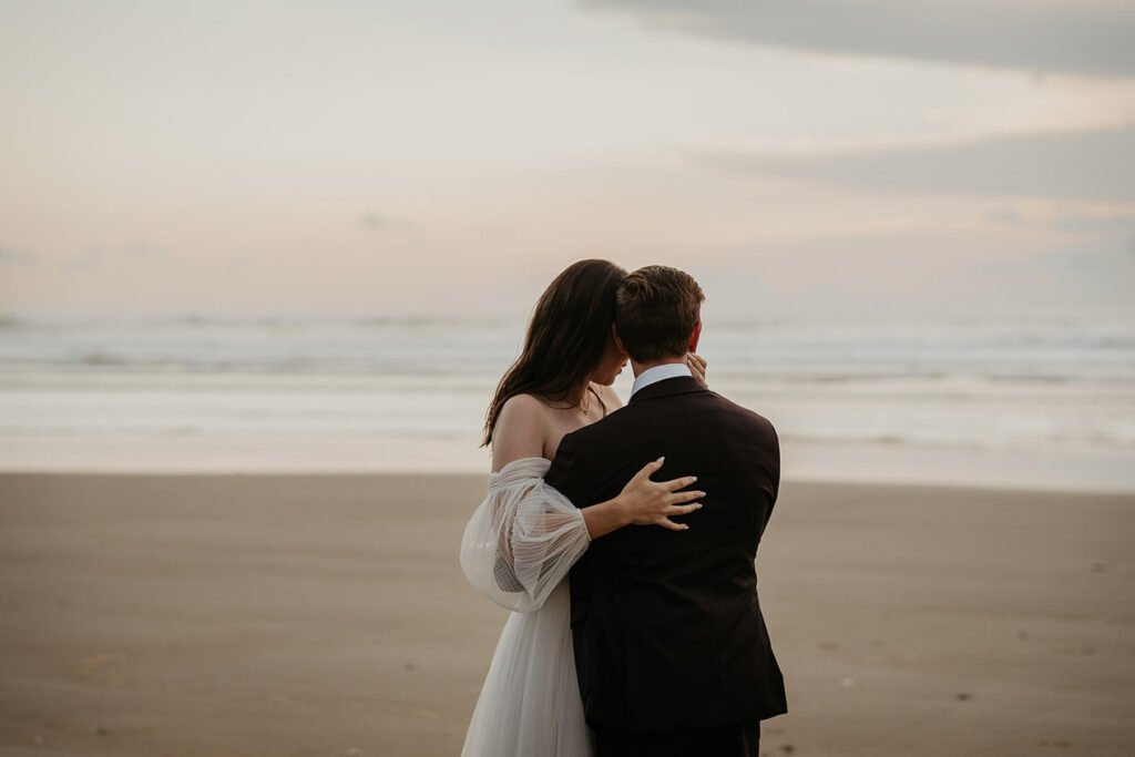 The newlyweds holding each other on the Oregon Coast. 