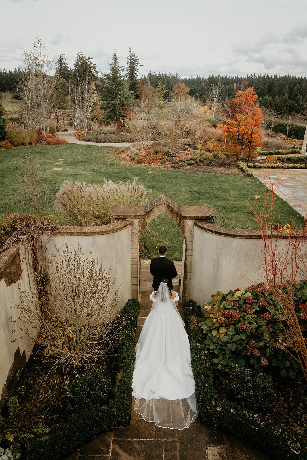 Bride walks up behind groom for their first look in a garden wedding venue