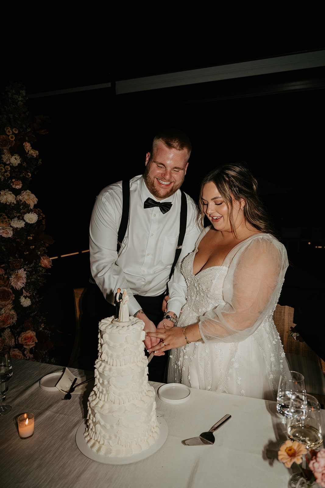 Bride and groom cut their three tier white frosted wedding cake at their Ironlight wedding reception in Oregon