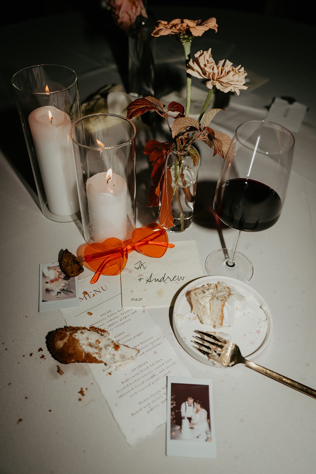 Half eaten cake and wine resting on top of a wedding recepetion table 