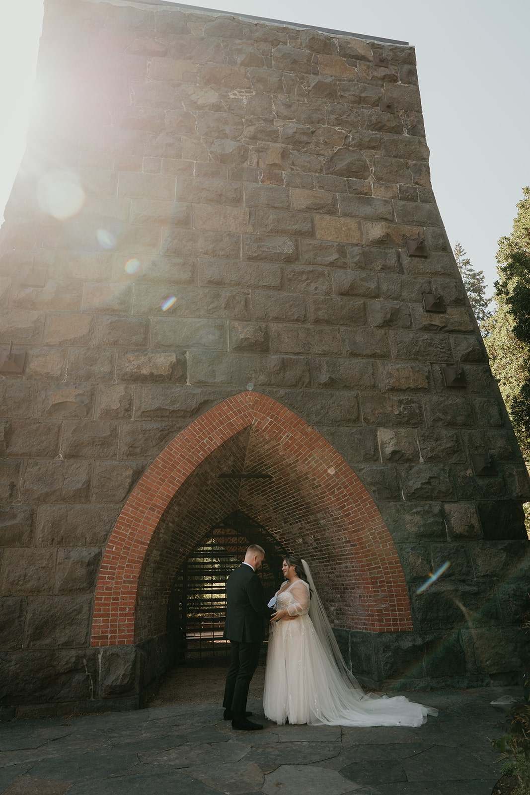 Bride and groom hold hands in a park during their Ironlight wedding couple photos