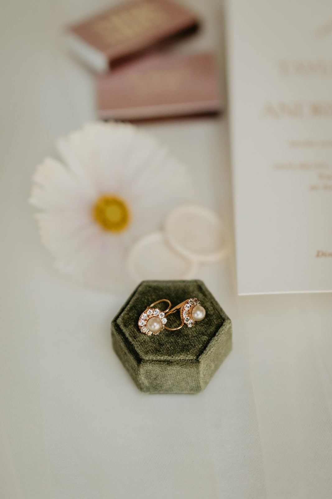 Green velvet ring box with white and rose wedding details 