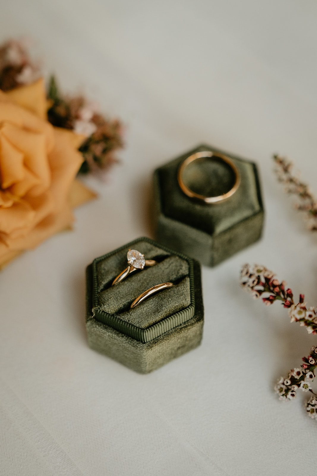 Green velvet ring box with gold wedding bands