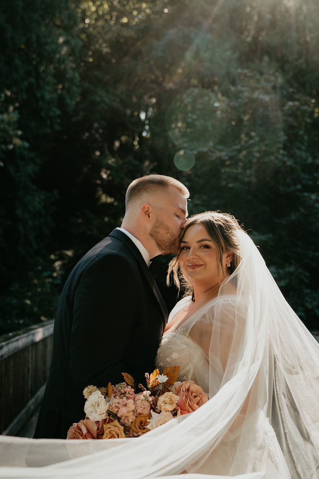 Groom kisses bride on the top of her head during their Ironlight Lake Oswego wedding photos 