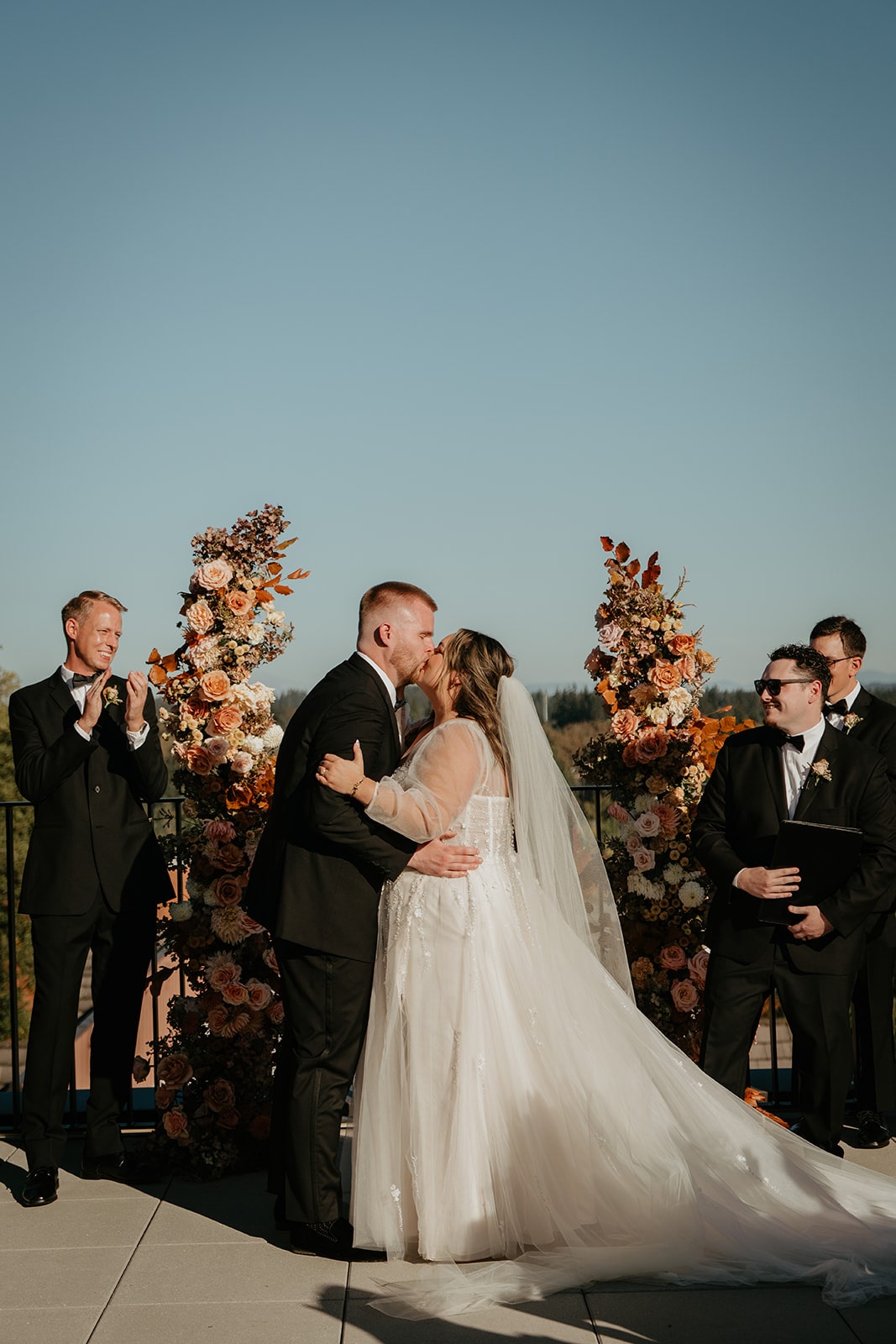 Bride and groom kiss during their Ironlight wedding on the rooftoop