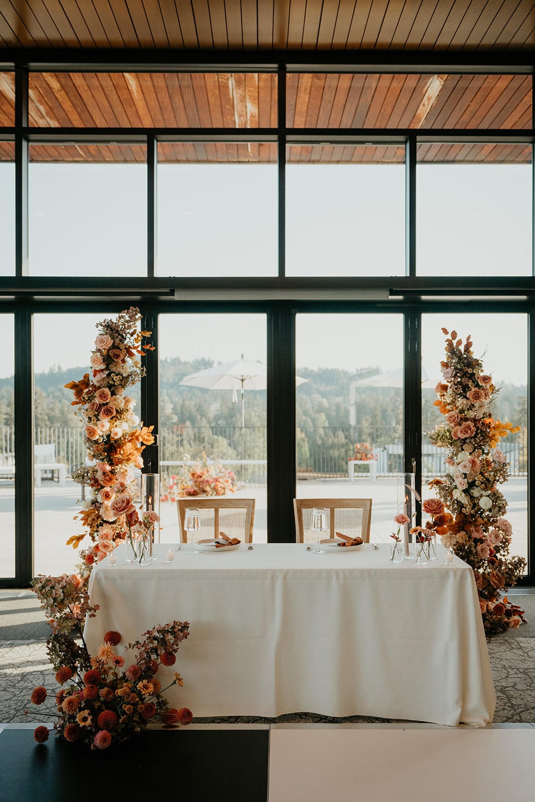 Sweetheart table surrounded by orange and beige flowers at Ironlight wedding venue in Oregon