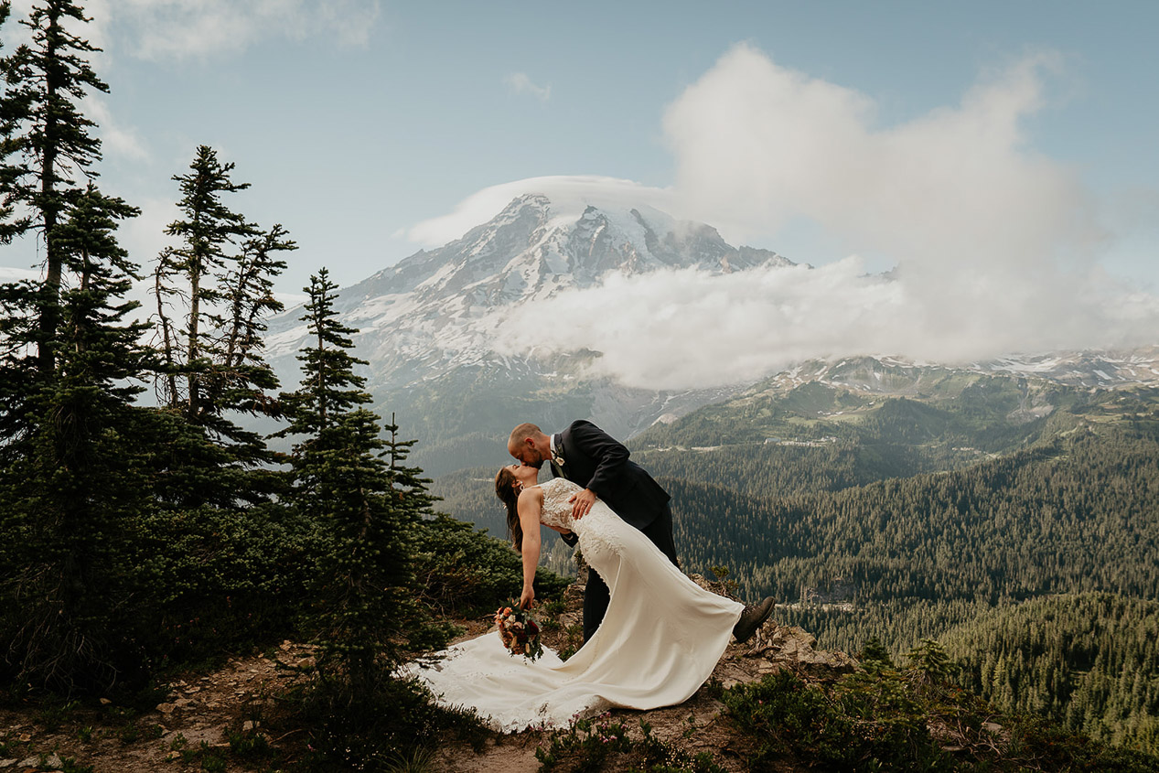 A couple kissing with Mount Rainier in the background during their pinnacle saddle elopement.