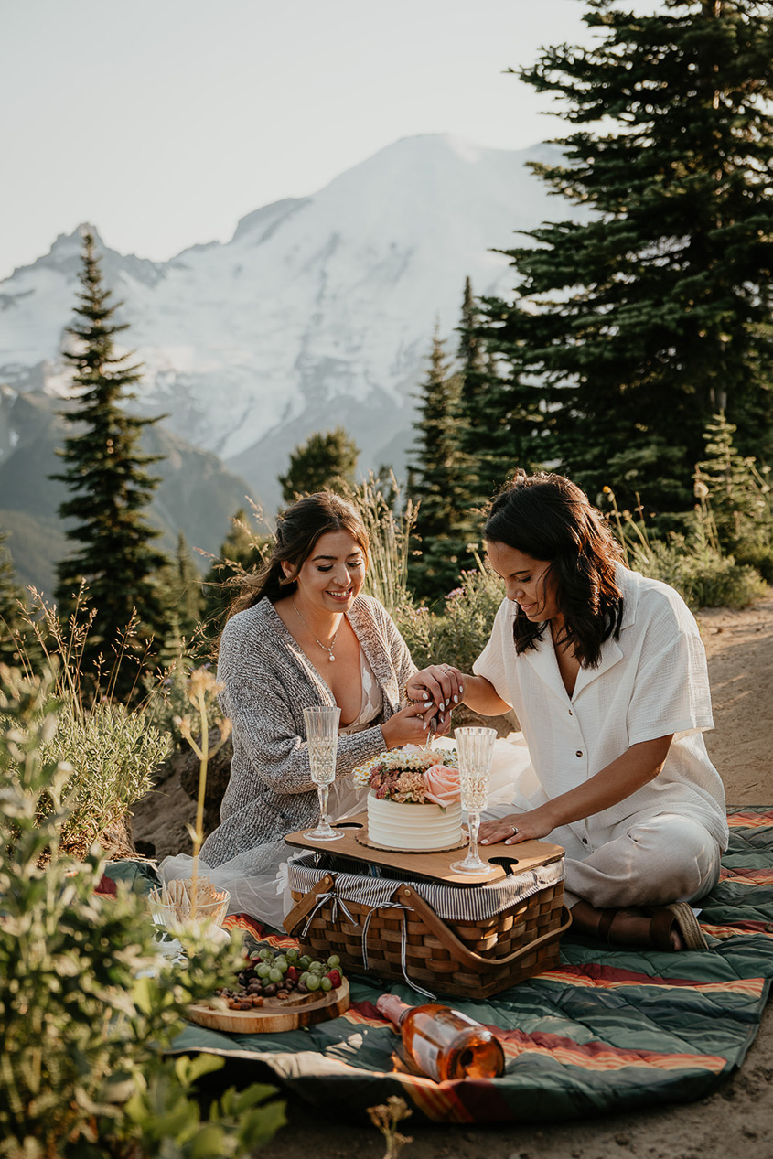 newlyweds enjoying a cake on a mountain.
