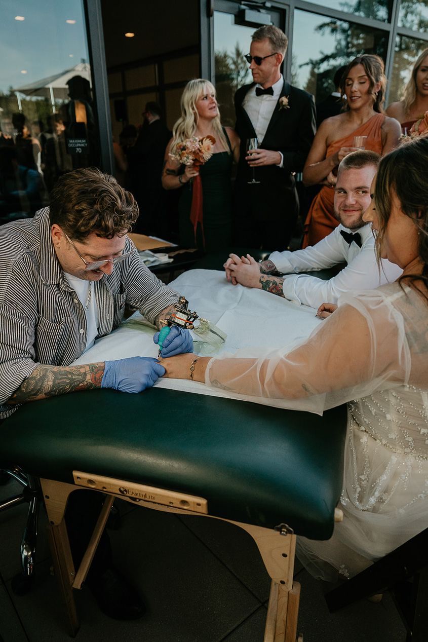 newlyweds getting a tattoo to commemorate their marriage.